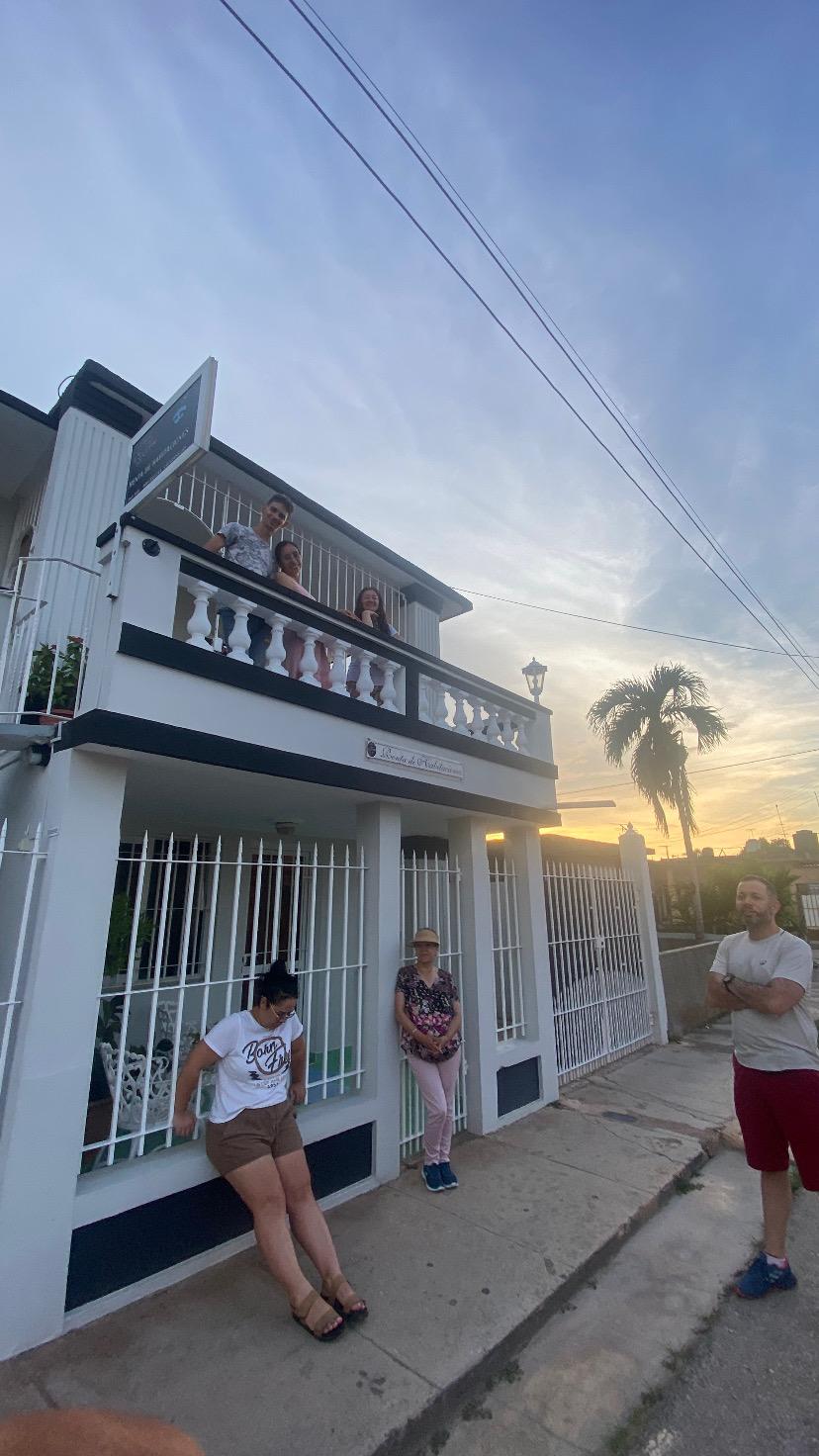 Sunset light on the Hostal Jose Cuba facade with family on the balcony
