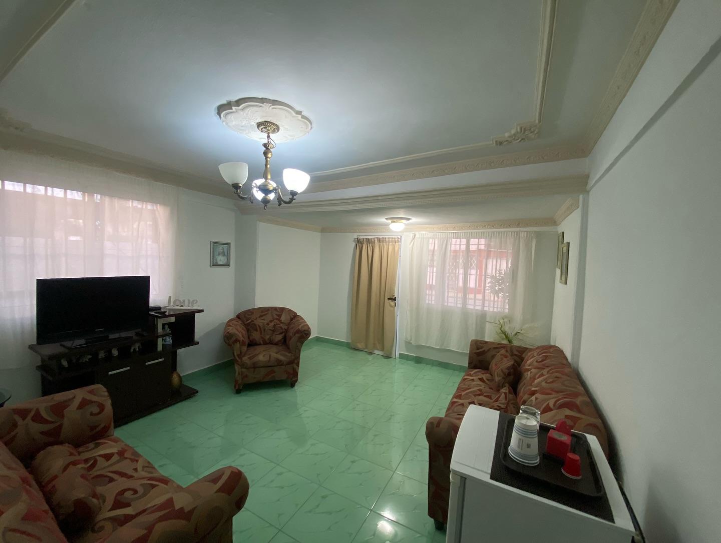Twin room with two single beds, dark green padded headboards, white linens and warm lighting