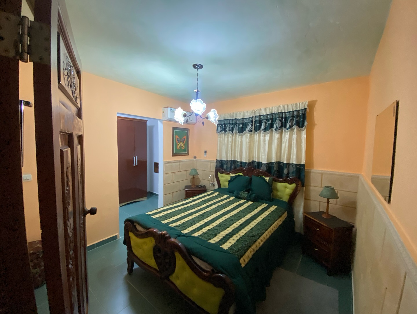 Double room with two beds, light wood headboards, a glowing bedside lamp and symmetrical composition