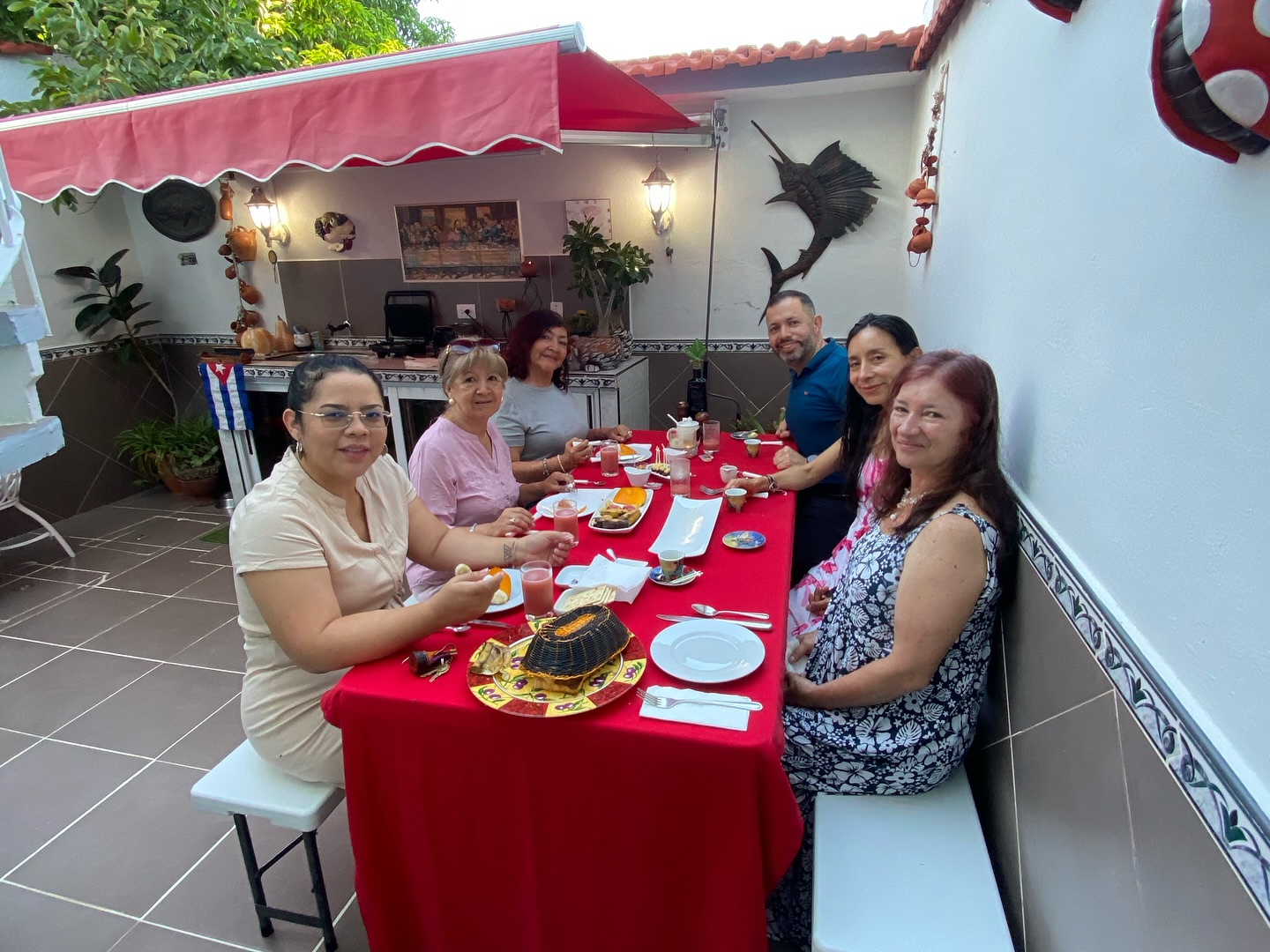 Jose, the host, in a white polo on the terrace with a guest at the breakfast table
